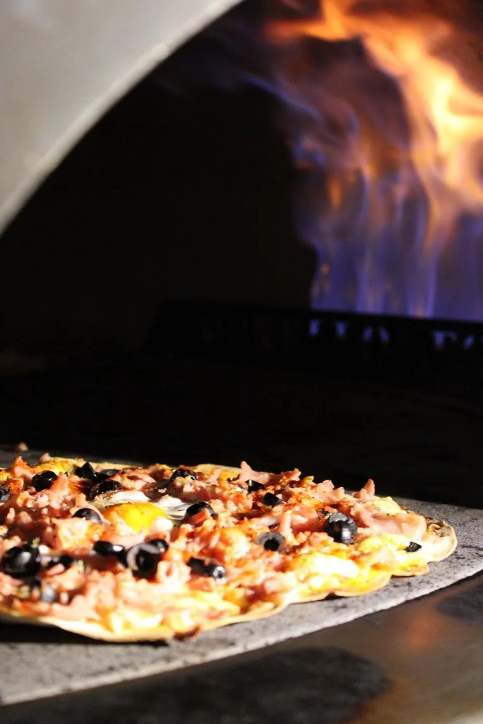 Pizza artesanal horneándose en el horno de leña